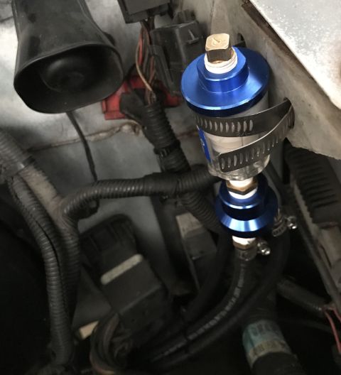 1995 Ford Bronco - Close-up of an aftermarket blue fuel filter installed in engine bay wiring.