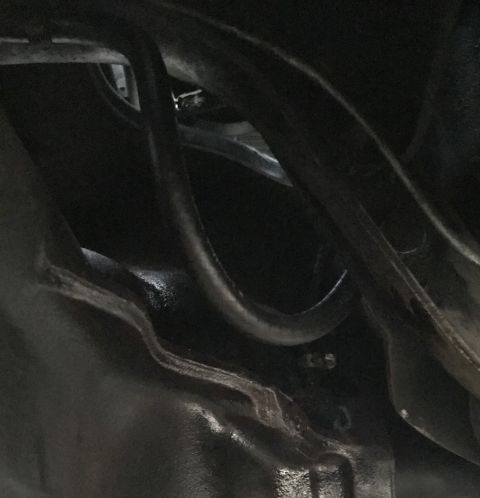 1995 Ford Bronco - A close-up view shows dark, curved metal tubing and a dark-colored engine block. Visible stamped numbers on the engine block read "135".
