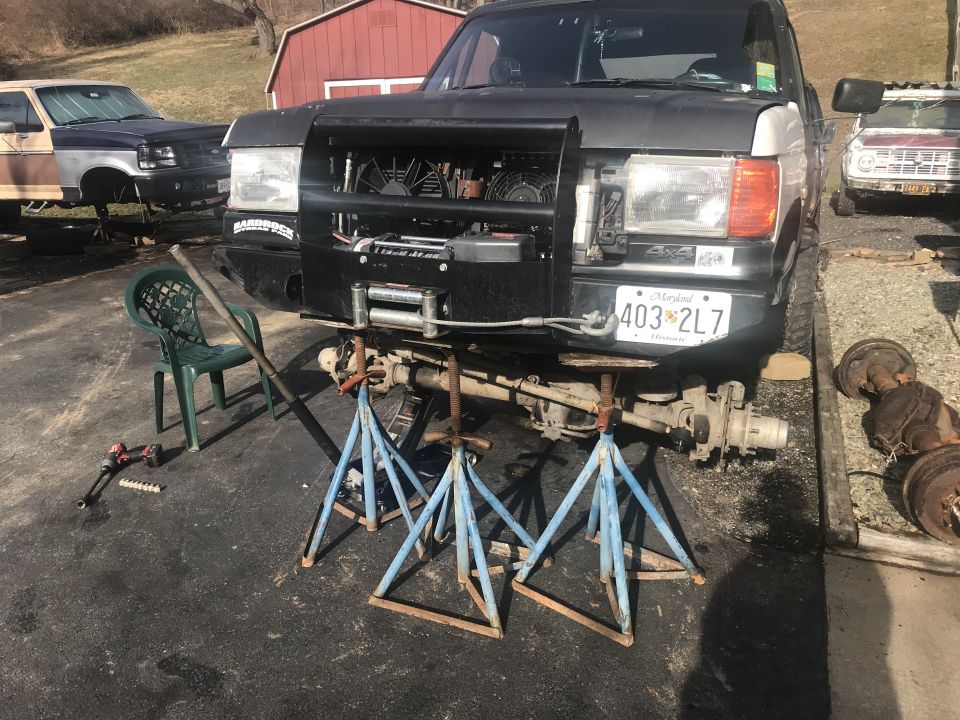 Black Ford Bronco on jack stands, front end disassembled, winch installed, Maryland license plate 403 2L7