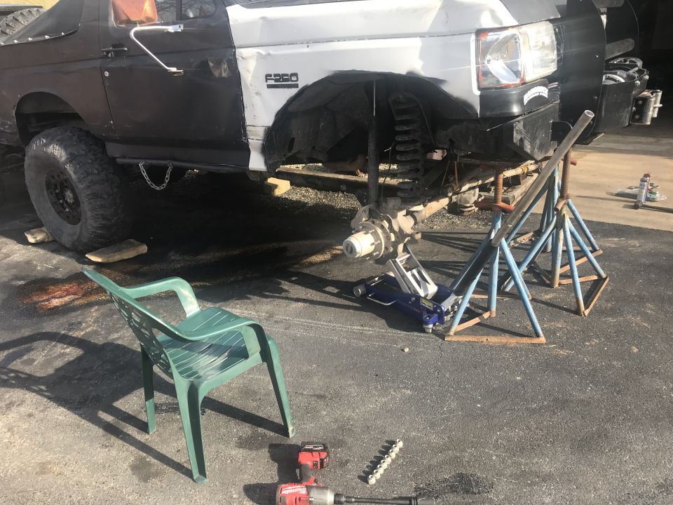 Front view of a black and white Ford F-250 truck with front suspension removed