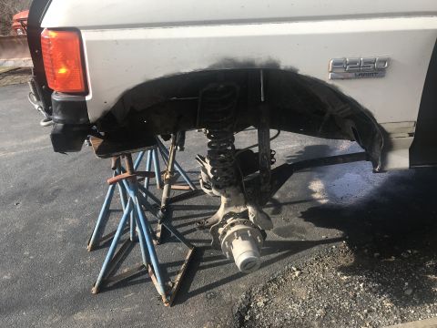 1989 Ford Bronco - Ford F-250 Lariat rear axle assembly undergoing work, supported by jack stands.