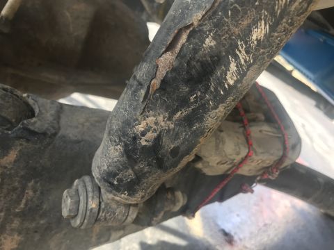 1989 Ford Bronco - A damaged shock absorber, likely from an older vehicle, shows significant wear and tear.