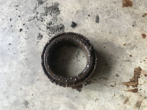 1989 Ford Bronco - A heavily used bearing sits on a concrete surface, showing signs of significant wear and tear.