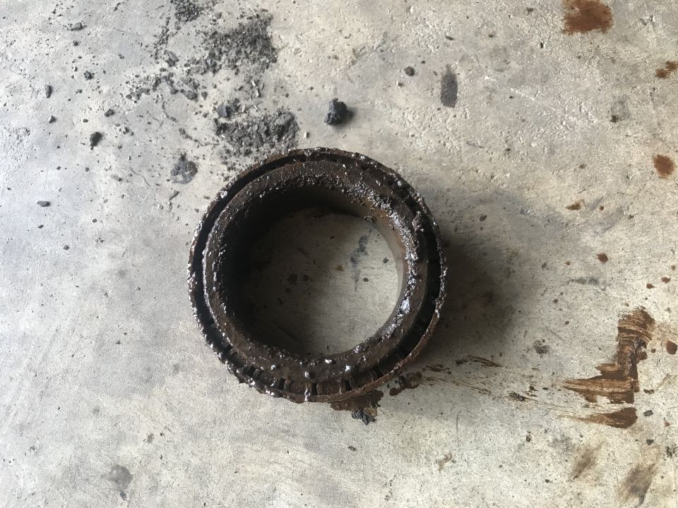Worn, greasy bearing on concrete floor