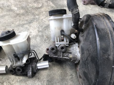 1993 Mazda MX-3 - This photo shows a brake master cylinder and booster assembly, likely for a vehicle repair or replacement.