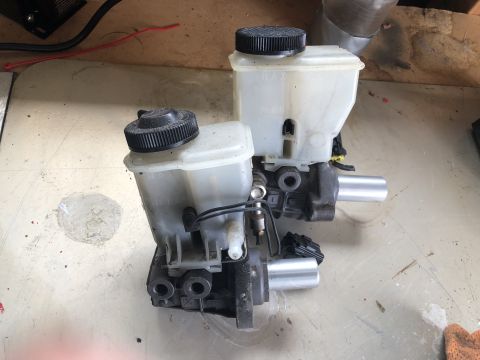 1993 Mazda MX-3 - A pair of brake master cylinder assemblies with plastic reservoirs and metal pistons are shown.