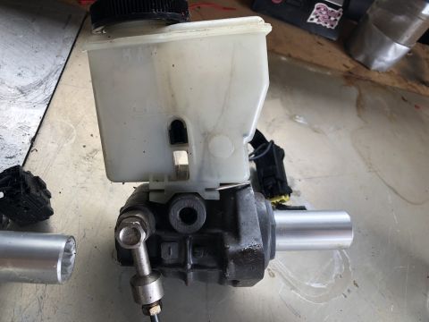 1993 Mazda MX-3 - A brake master cylinder assembly with a plastic fluid reservoir is shown, likely removed for maintenance or replacement.
