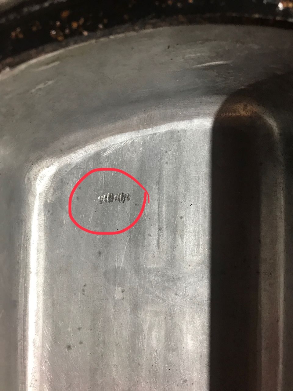 Close-up of a maker's mark on a metal pan.