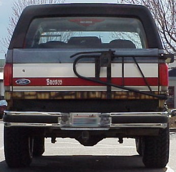 1989 Ford Bronco - The rear of a Ford Bronco shows a spare tire carrier and a trailer hitch.