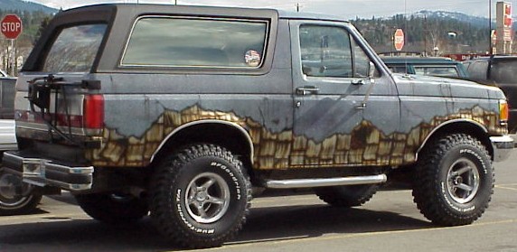 Gray Ford Bronco with mountain-themed paint job and off-road tires