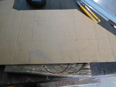 1992 Ford Bronco - A piece of cardboard with a template drawn on it is placed on a wooden surface. A utility knife and metal rulers are visible in the backgro…