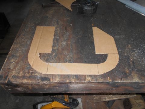 1992 Ford Bronco - A cardboard template is laid out on a workbench. The template is shaped like a stylized "U" with angled ends.