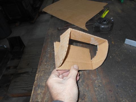 1992 Ford Bronco - A hand is holding a piece of bent cardboard that is shaped like a bracket or a housing. Other pieces of cardboard and a tape measure are vi…