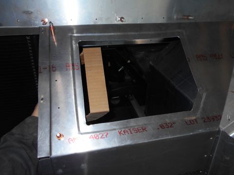1992 Ford Bronco - A close-up view of the interior of a vehicle's metal construction, showing a rectangular opening with a piece of cardboard inserted. Red ma…