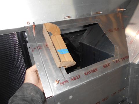 1992 Ford Bronco - A hand is holding a piece of cardboard over a large opening in an aluminum structure. The structure has red lettering indicating material s…
