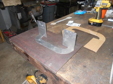 1992 Ford Bronco - A metal template is laid out on a workbench next to a cardboard template and a cordless drill. The workbench is cluttered with tools and ma…