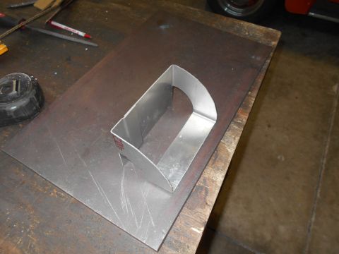 1992 Ford Bronco - A metal template is placed on a sheet of metal on a workbench. Tools and a tape measure are visible in the background.