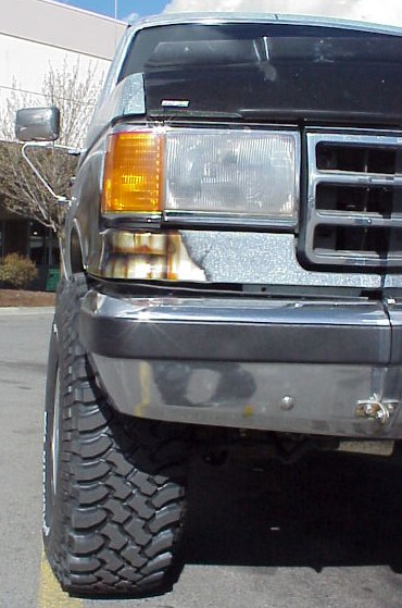 1989 Ford Bronco - Front view of a 1989 Ford Bronco, highlighting its large off-road tires and distinctive grille.
