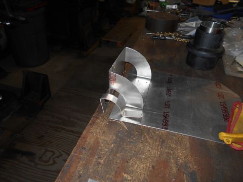 1992 Ford Bronco - A metal fabrication project is underway on a workbench. The project involves bending and shaping pieces of sheet metal into a complex, curv…