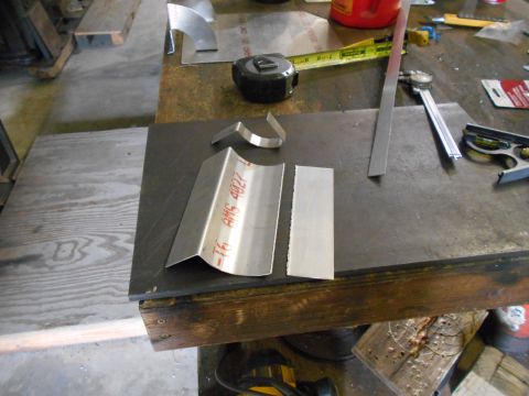 1992 Ford Bronco - Metalworking tools and cut pieces of metal are laid out on a workbench. A tape measure, calipers, and a metal ruler are visible among the m…