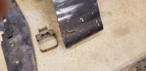 1970 Pontiac GTO — Rusted black metal car panel and bracket on concrete