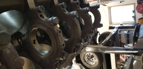 1970 Pontiac GTO — Close-up of engine block main bearing caps and cylinder bores, with vehicle frame and tire in background.