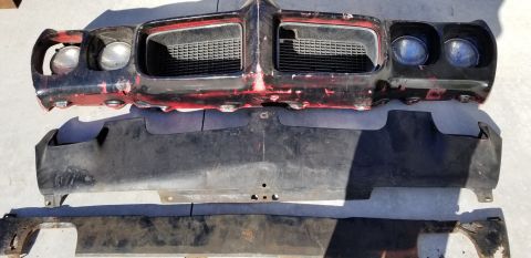 1970 Pontiac GTO — Disassembled front end of a vintage car including grille, headlights, air dam, and bumper.