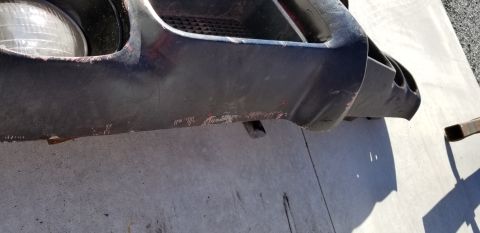 1970 Pontiac GTO — Close-up of worn dark bumper and headlight area of a classic car.