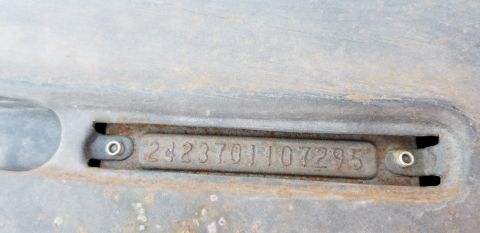 1970 Pontiac GTO — Close-up of a VIN plate with numbers 2423701107295 on a rusty surface.