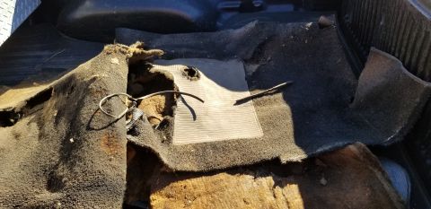 1970 Pontiac GTO — Worn and ripped interior carpet in a vehicle with a rubber mat underneath.