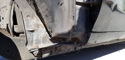 1970 Pontiac GTO — Rusted lower body and rocker panel area of a vehicle with corrosion and damaged sheet metal
