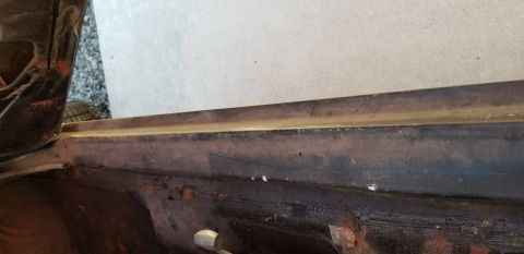 1970 Pontiac GTO — Weathered interior rocker panel and door jamb of a vintage car with rust.