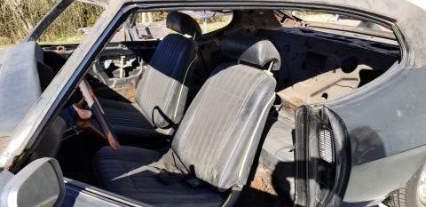 1970 Pontiac GTO — Interior of a classic coupe with black bucket seats and steering wheel.