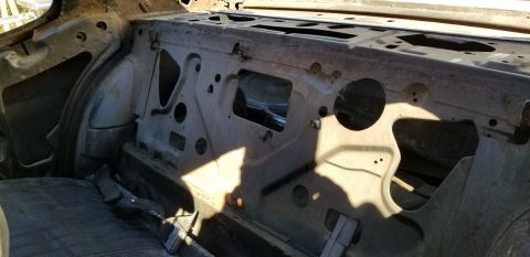 1970 Pontiac GTO — Interior of a classic car showing the rear firewall and seat area with sunlight and shadows.