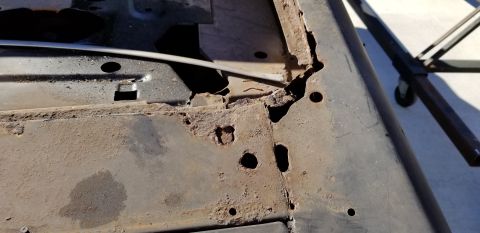 1970 Pontiac GTO - A close-up view of heavily rusted and corroded metal, likely a vehicle frame or body panel, showing significant holes and deterioration. Th…