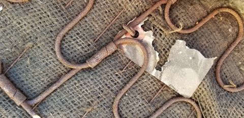 1970 Pontiac GTO - A close-up view shows rusted metal springs and torn fabric, likely from the underside of a vintage car seat.