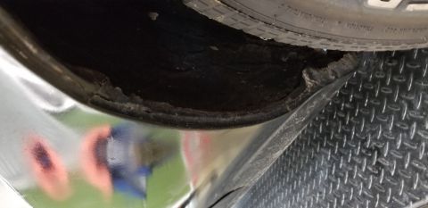 1970 Pontiac GTO - A close-up view shows significant rust and damage to the inner fender well of a vehicle, with a tire visible at the top. The exterior body…