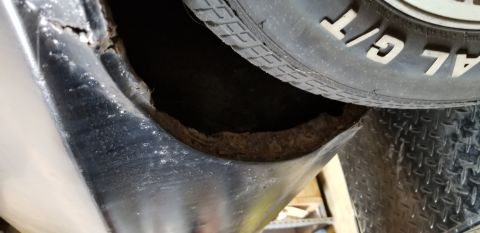 1970 Pontiac GTO - Severe rust damage is visible on the inner wheel well of a vehicle, with a tire partially obscuring the view. The surrounding body panel ap…