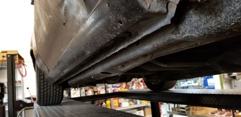 1970 Pontiac GTO - A low-angle, close-up view shows the underside of a vehicle's rocker panel and frame, which appears to be on a car lift. The metal shows si…