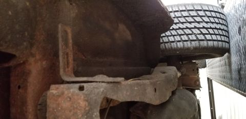 1970 Pontiac GTO - The underside of a vehicle's frame and suspension components are shown, heavily rusted. A tire is visible on the right side of the frame.