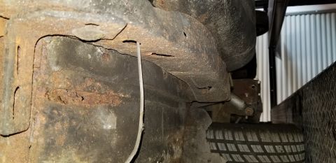1970 Pontiac GTO - The underside of a vehicle's frame shows significant rust and corrosion. A white wire hangs down near the rusted metal.