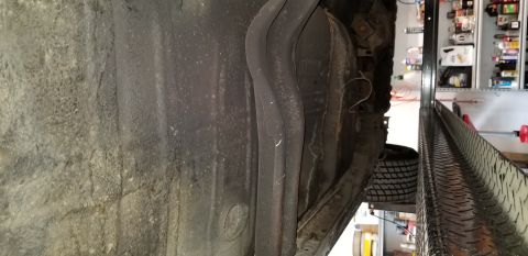 1970 Pontiac GTO - The underside of a vehicle, likely a 1970 Pontiac GTO, shows the fuel tank and exhaust system mounted to the frame. The vehicle is raised o…