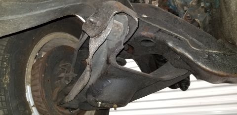 1970 Pontiac GTO - This is a close-up, low-angle shot of the underside of a vintage vehicle's front suspension system, showing the control arms, ball joint, a…