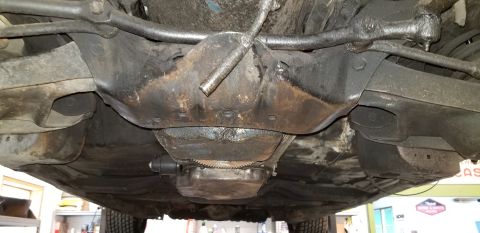 1970 Pontiac GTO - The underside of a classic car, likely a 1970 Pontiac GTO, shows the front suspension and drivetrain components. The frame and engine compo…