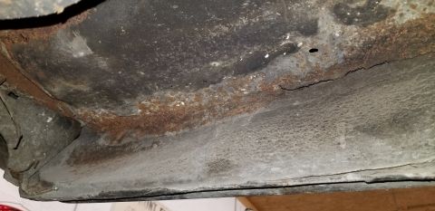 1970 Pontiac GTO - The underside of a vehicle shows significant rust and corrosion along a seam. A crack is visible in the metal near the rusted area.