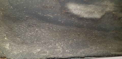 1970 Pontiac GTO - This is a close-up, low-angle shot of the underside of a vehicle, likely the frame or undercarriage. The surface is dark, textured, and app…