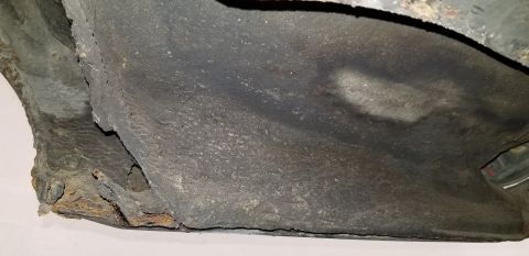 1970 Pontiac GTO - The underside of a vehicle shows significant rust and damage along the edge of what appears to be a rocker panel or frame rail. The surface…