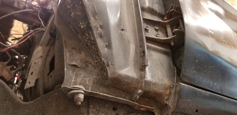 1970 Pontiac GTO - This close-up image shows the rusted and dented inner fender well and engine bay components of a vehicle, likely a classic car undergoing r…