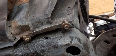 1970 Pontiac GTO - This is a close-up shot of heavily rusted and corroded metal components, likely part of a vehicle's chassis or frame. Several bolts with wa…