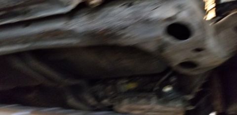1970 Pontiac GTO - This is a close-up, blurry, low-angle shot of the underside of a vehicle, likely the frame or subframe, showing some metal components and p…